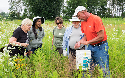 People gathered around learning about native plants