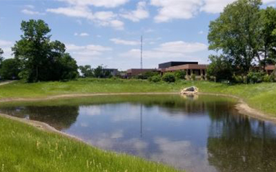 Pond reflecting sky with a building in the background