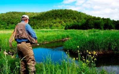 person in fishing clothes and gear standing next to Vermont Creek courtesy Mario Quintana