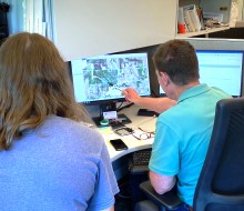 Two people looking at a aerial image on a computer screen.